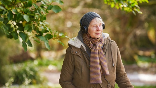 Visitor listening to headphones in the grounds at Knightshayes, Devon